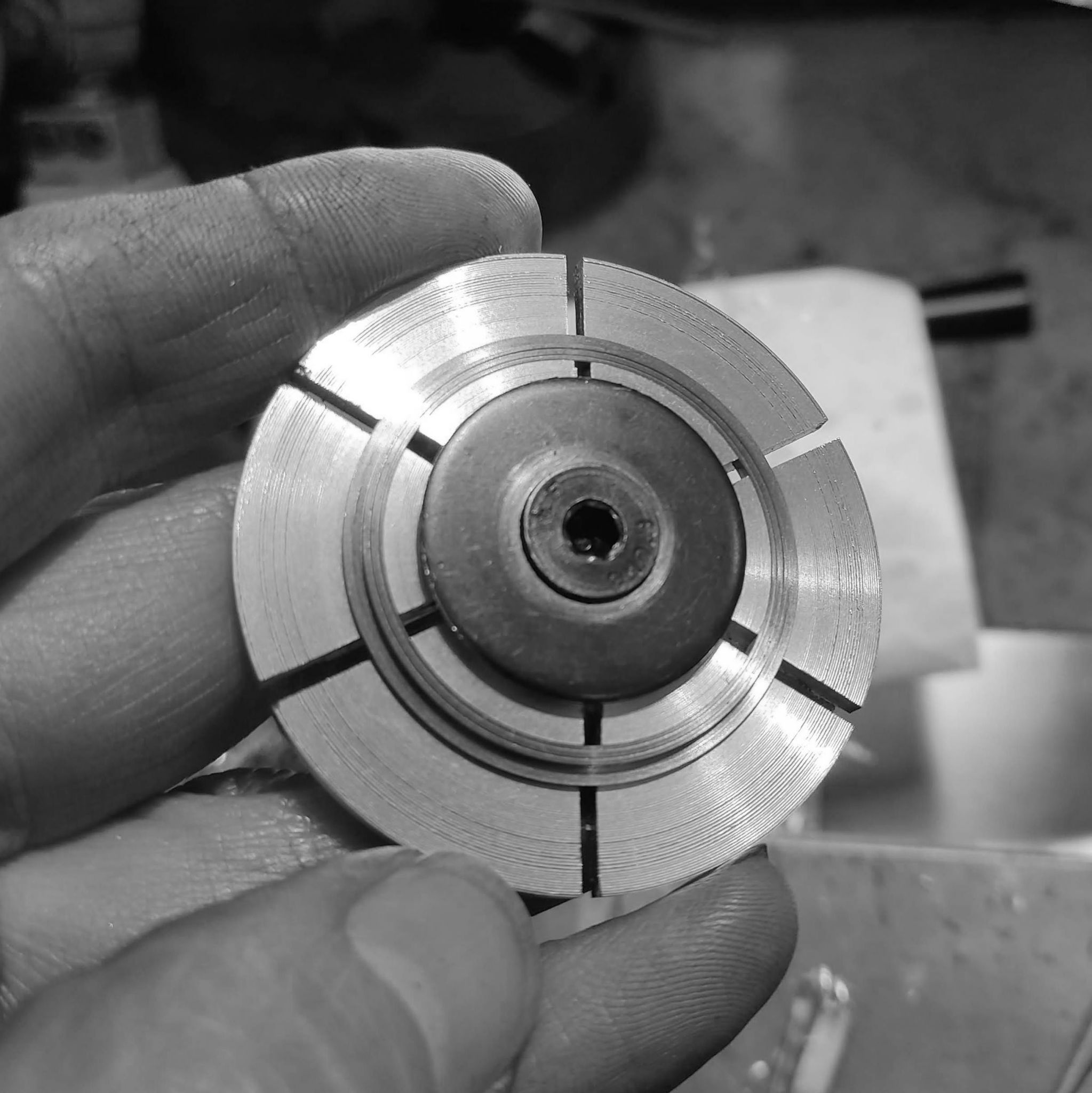 The dial being held by the expanding collet jig. The center screw is tightened, forcing the jaws outwards, and securely holding the dial.