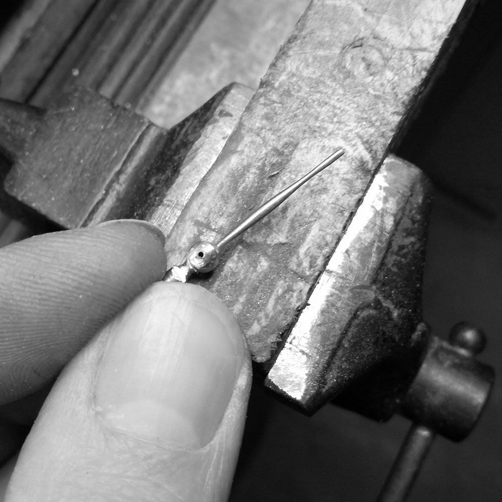 Hand filing of minute hand (end 'pip' will be cut off in the final stages).