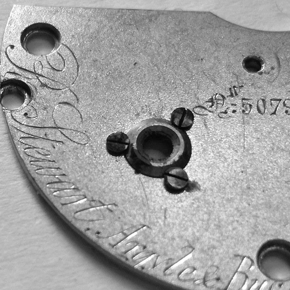 The traditional brass mainspring arbor bushing on English watches. Here has some surface rust.